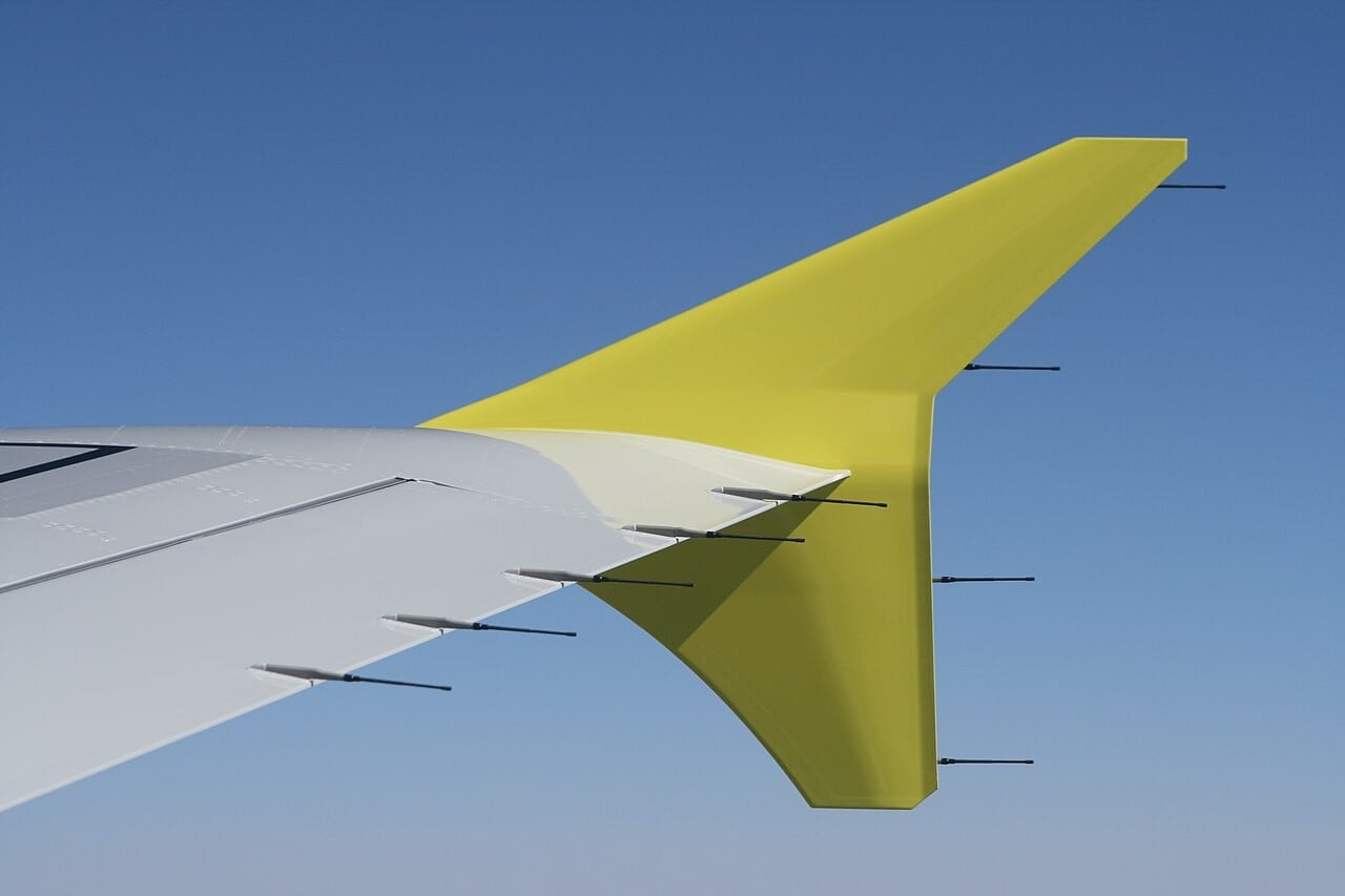 The wingtip fence of an Airbus A319 with several thin static discharger rods pointing backwards from the trailing edges