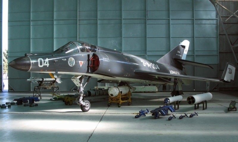 Argentine Navy Super Etendard 3-A-204 displayed in a hangar with missiles and weapons laid out beside it