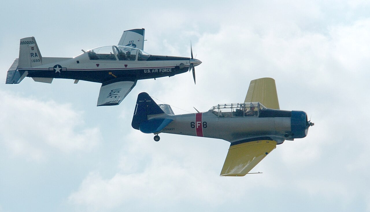 A T-6A Texan II flying alongside an original North American T-6 Texan