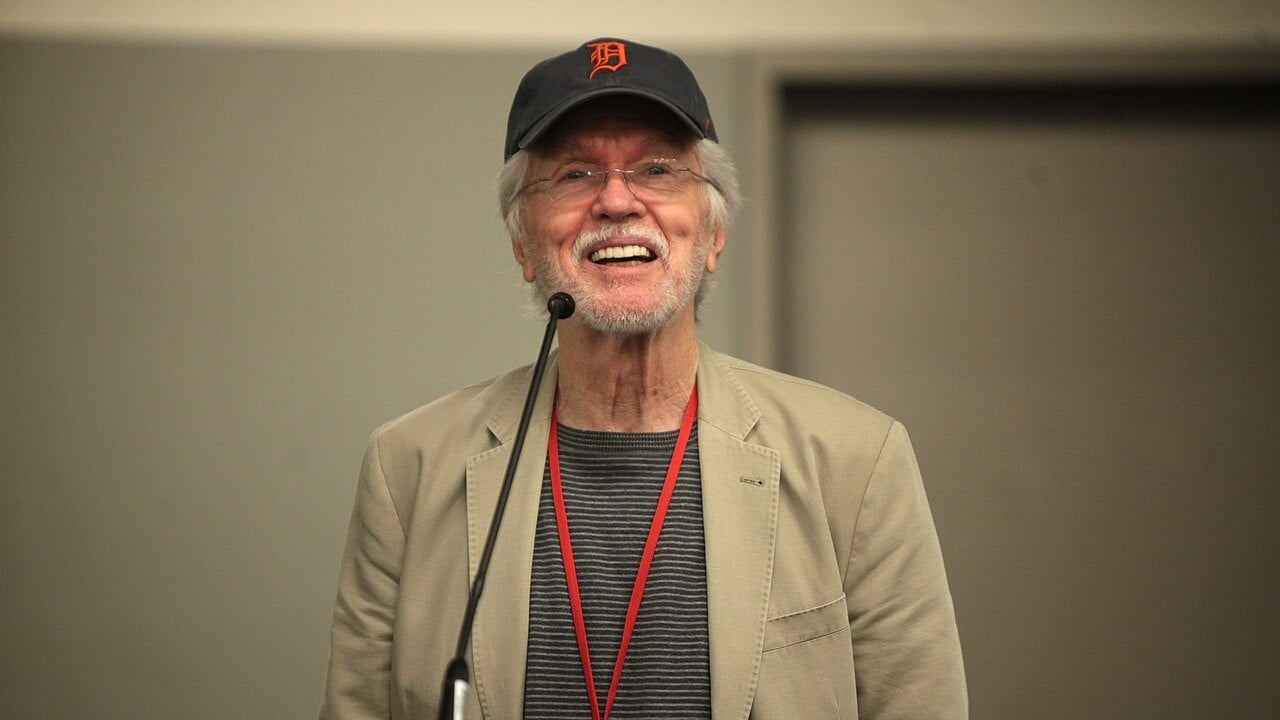 Actor and US Air Force veteran Tom Skerritt smiling at a lectern in 2014, wearing a Detroit Tigers cap