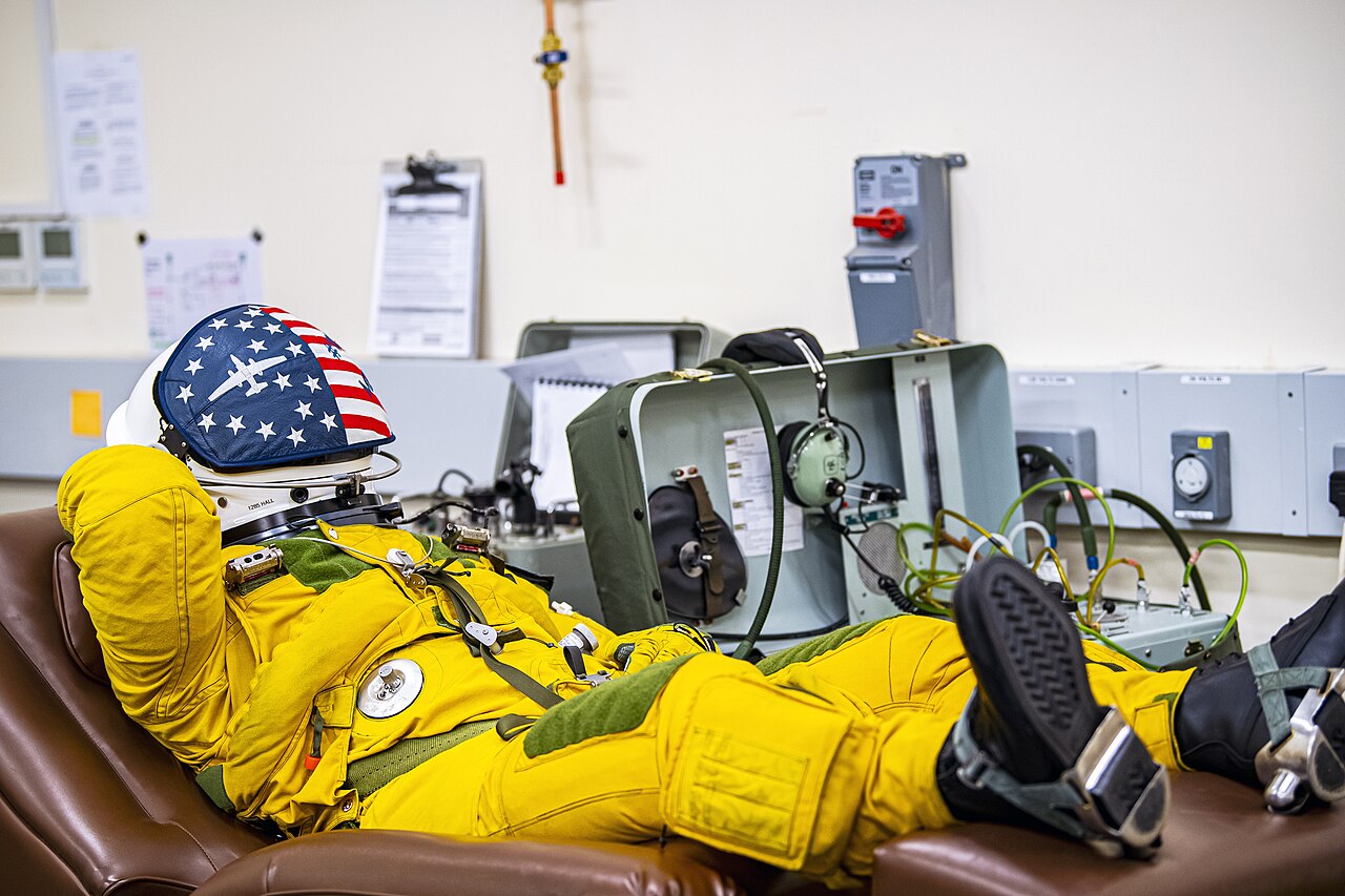 U-2 Dragon Lady pilot reclined in a full-pressure suit connected to a portable oxygen console