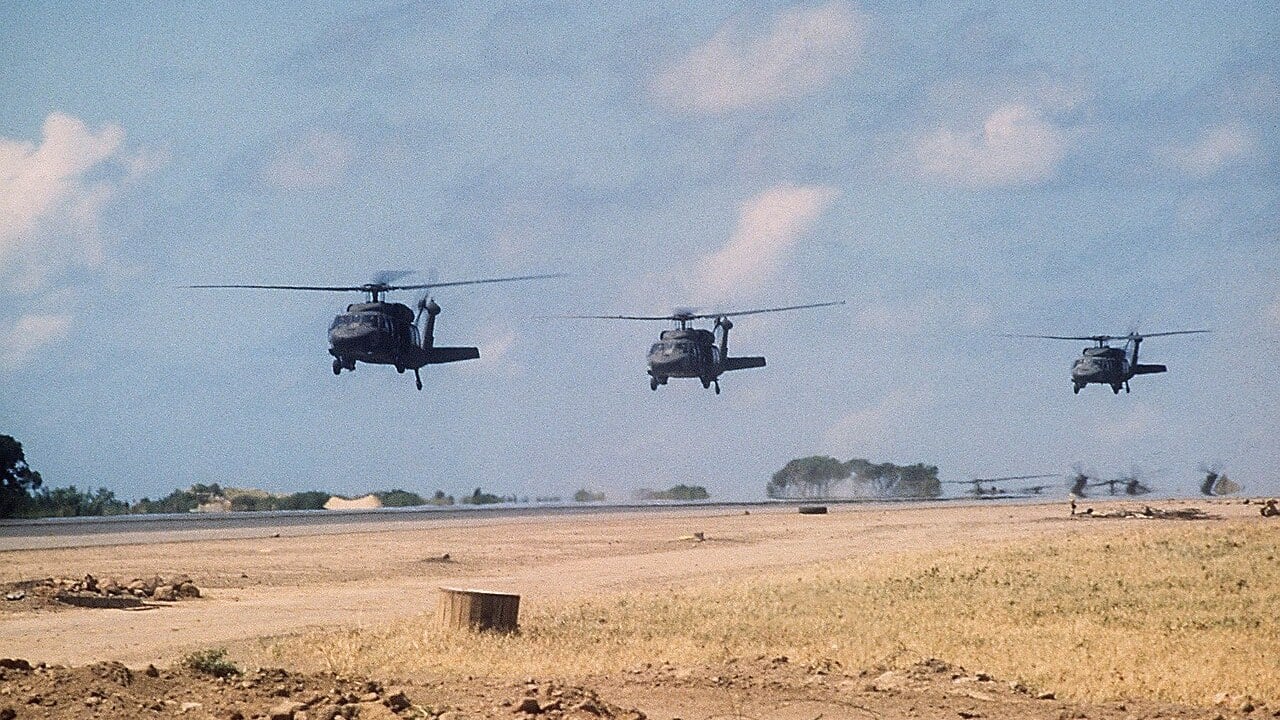 Three US Army UH-60A Black Hawk helicopters touching down beside the Point Salines runway in Grenada on 25 October 1983