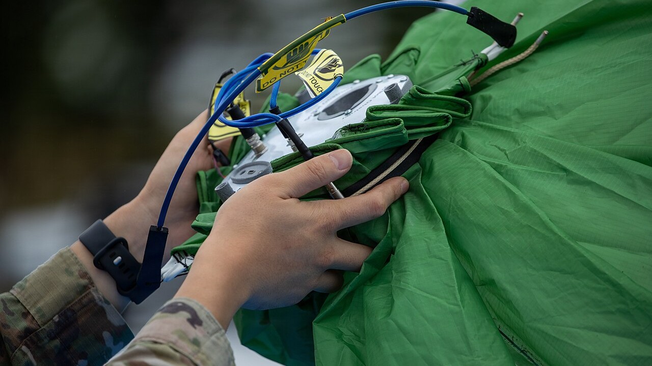 A US Army soldier prepares a micro high-altitude balloon payload during Orient Shield 26
