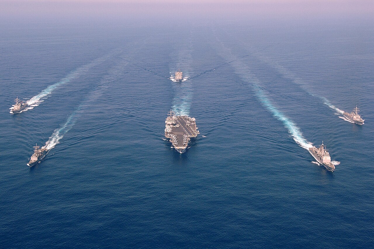 USS Enterprise carrier strike group sailing in formation in the Atlantic with escorts and a supply ship