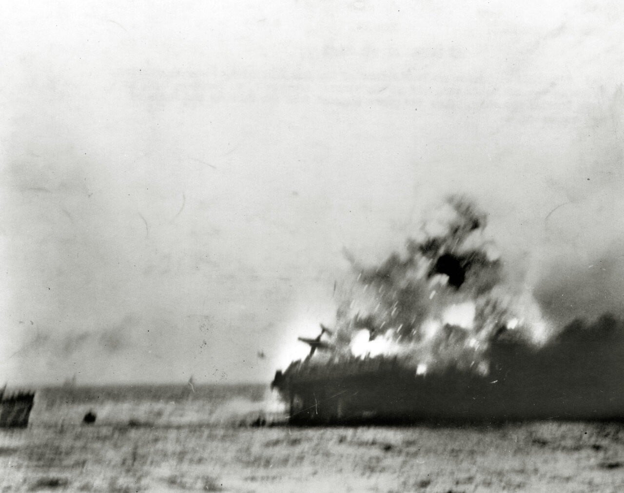 A heavy explosion aboard USS Lexington blows an aircraft over her side, 8 May 1942