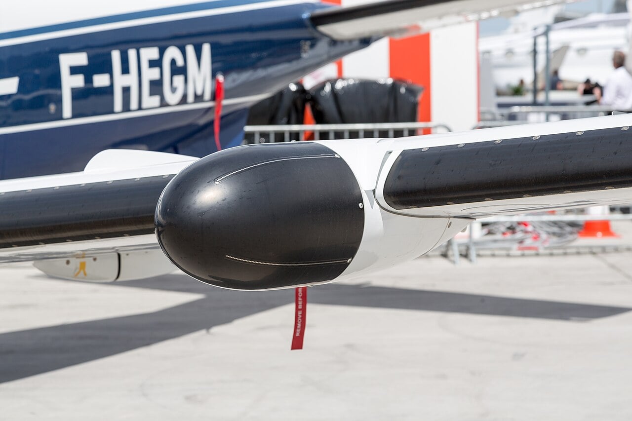 Black weather radar radome pod under the wing of a Daher TBM turboprop at EBACE 2018