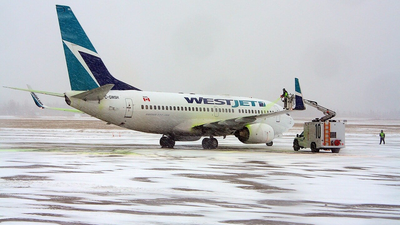 WestJet Boeing 737 being sprayed with Type IV anti-icing fluid A WestJet Boeing 737-700 on a snowy apron being sprayed with green Type IV anti-icing fluid from a de-icing truck