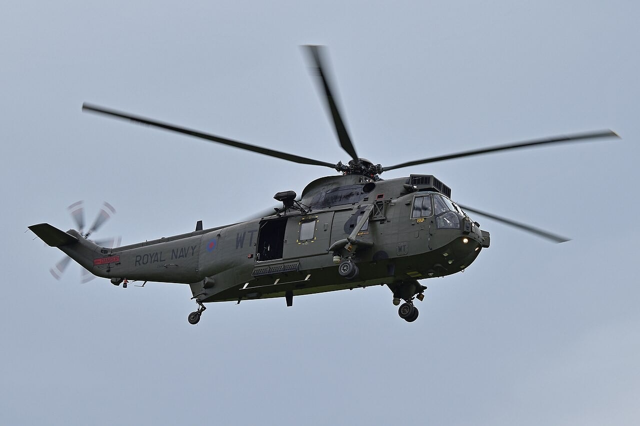 A green Royal Navy Westland Sea King HC.4 commando helicopter in flight