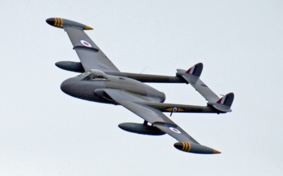 A de Havilland Venom banking in flight  the twin-boom silhouette that marked de Havillands first jet generation.