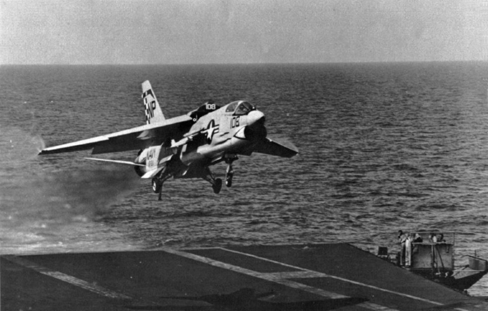An F-8E of VF-211 on a carrier approach  the variable-incidence wing raised for landing.