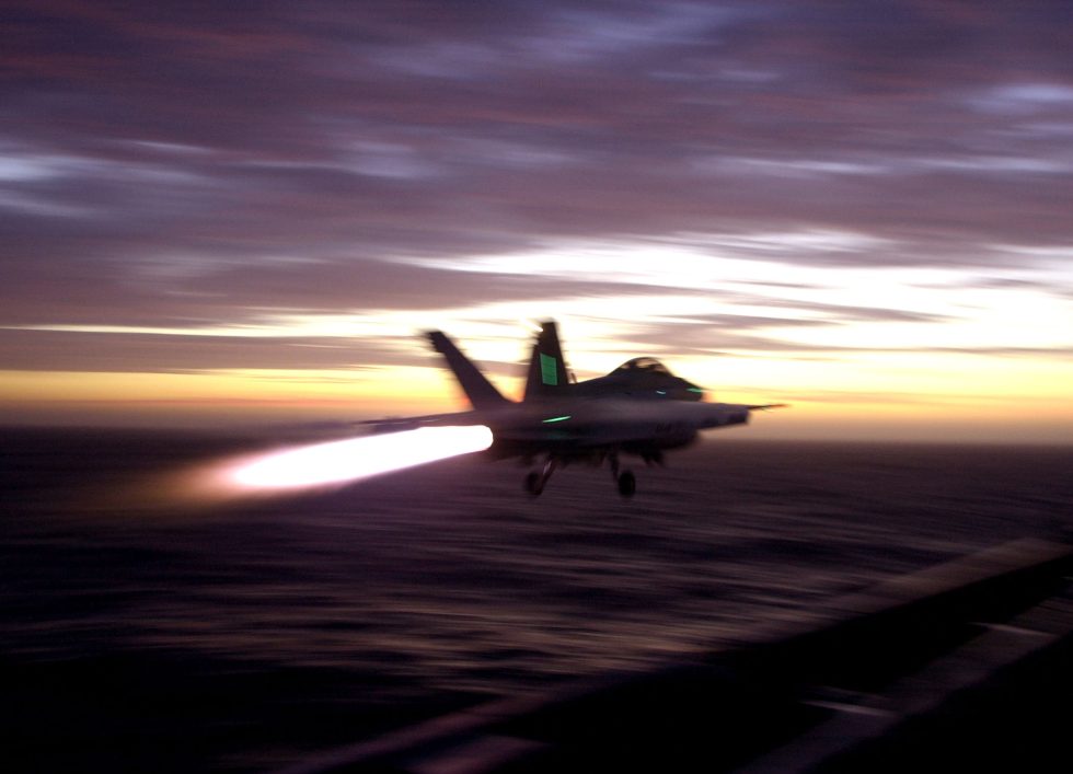 An F/A-18F lighting its two F414 afterburners about a third more thrust than the legacy Hornet.