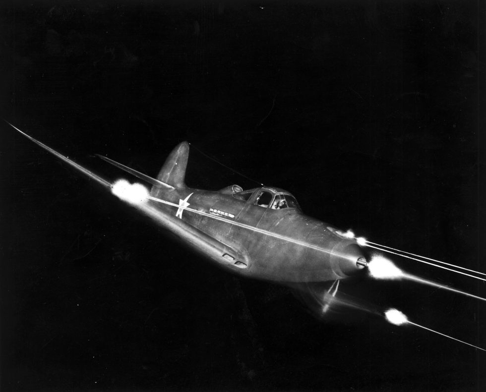 A P-39 firing all weapons at night  the 37mm cannon and machine guns lighting the dark.