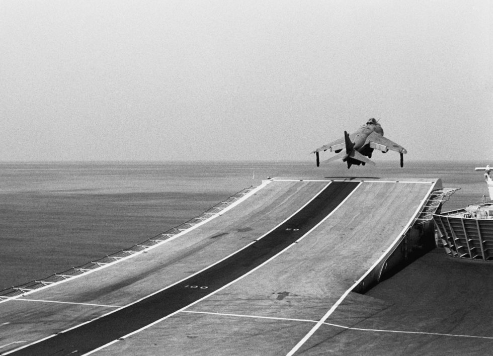A Royal Navy Sea Harrier FRS.1 launching off the ski-jump of HMS Invincible in 1990.