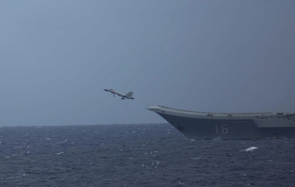 A J-15 over a Chinese carrier at sea the Flying Shark launches by ski-jump and recovers on the arrestor wire.