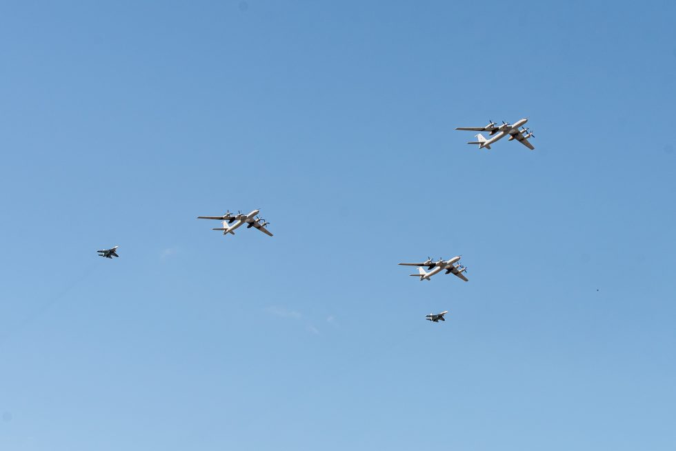 A Su-33 banks overhead in a Navy Day flypast, its planform and hardpoints in view.