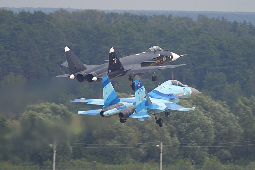 The Su-47 in flight alongside a Su-35UB at MAKS-2003  forward-swept wings and canards clearly visible.