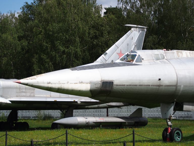 The pointed nose and cockpit of a museum Tu-22, with a Raduga Kh-22 standoff missile displayed beneath.