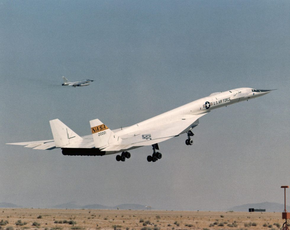 AV-1 lifting off on a research flight with a chase aircraft alongside.