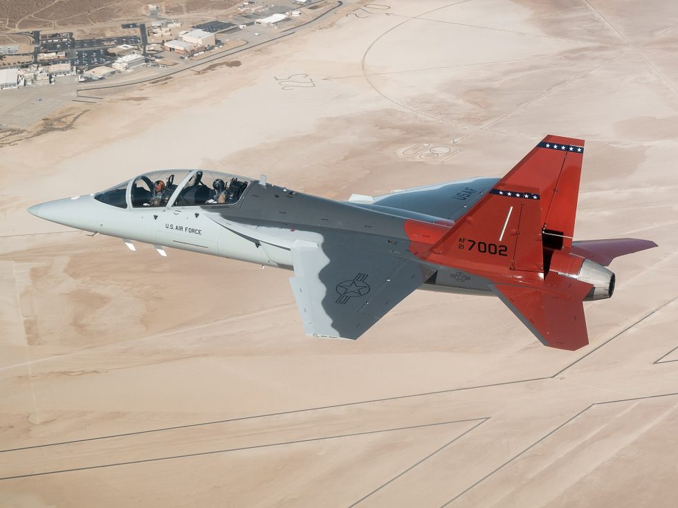 A T-7A Red Hawk banks over Edwards Air Force Base during developmental flight test.