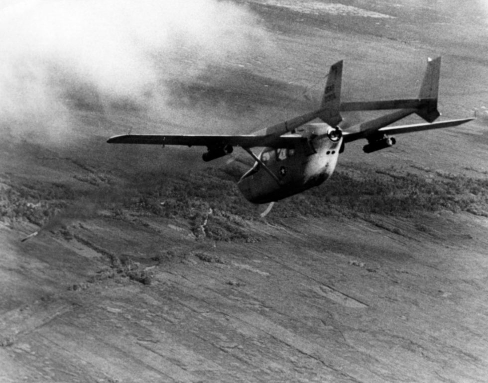 A Cessna O-2A Skymaster banking as it fires a white phosphorus marking rocket to mark a target in Vietnam