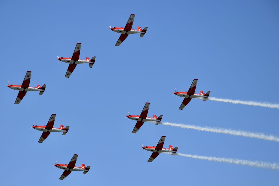 The Swiss PC-7 TEAM in formation  nine standard Pilatus PC-7s trailing smoke over Switzerland.